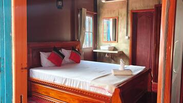 Un dormitorio con una cama de madera, una mesita de noche, un espejo y una ventana con cortinas.
