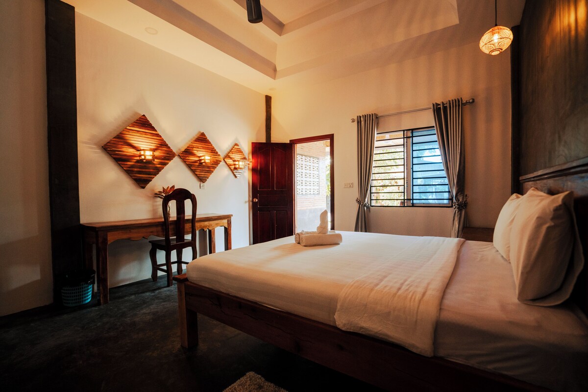 Una habitación de hotel con una cama grande, un escritorio y una silla.
