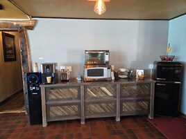 Una kitchenette equipada con cafetera, tostadora, microondas y refrigerador.