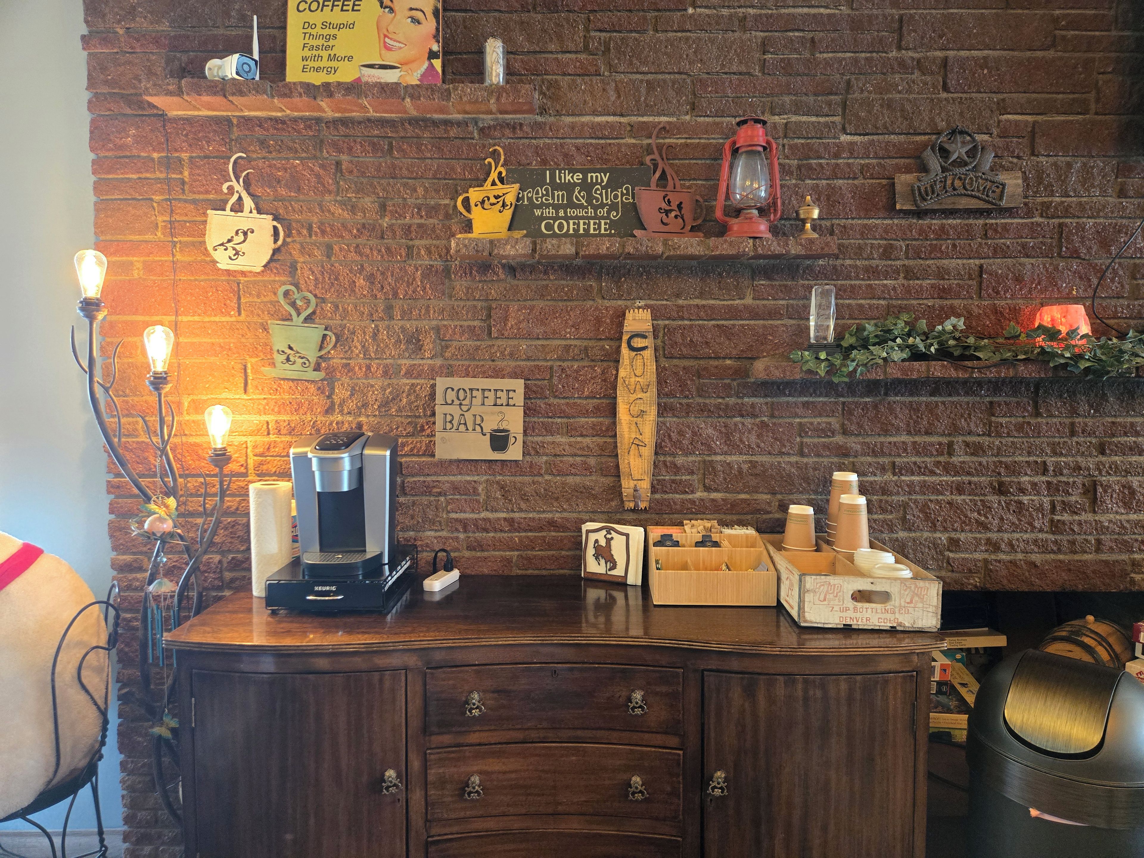 A coffee bar with a brick wall, coffee-making equipment, and various coffee-related decorations.