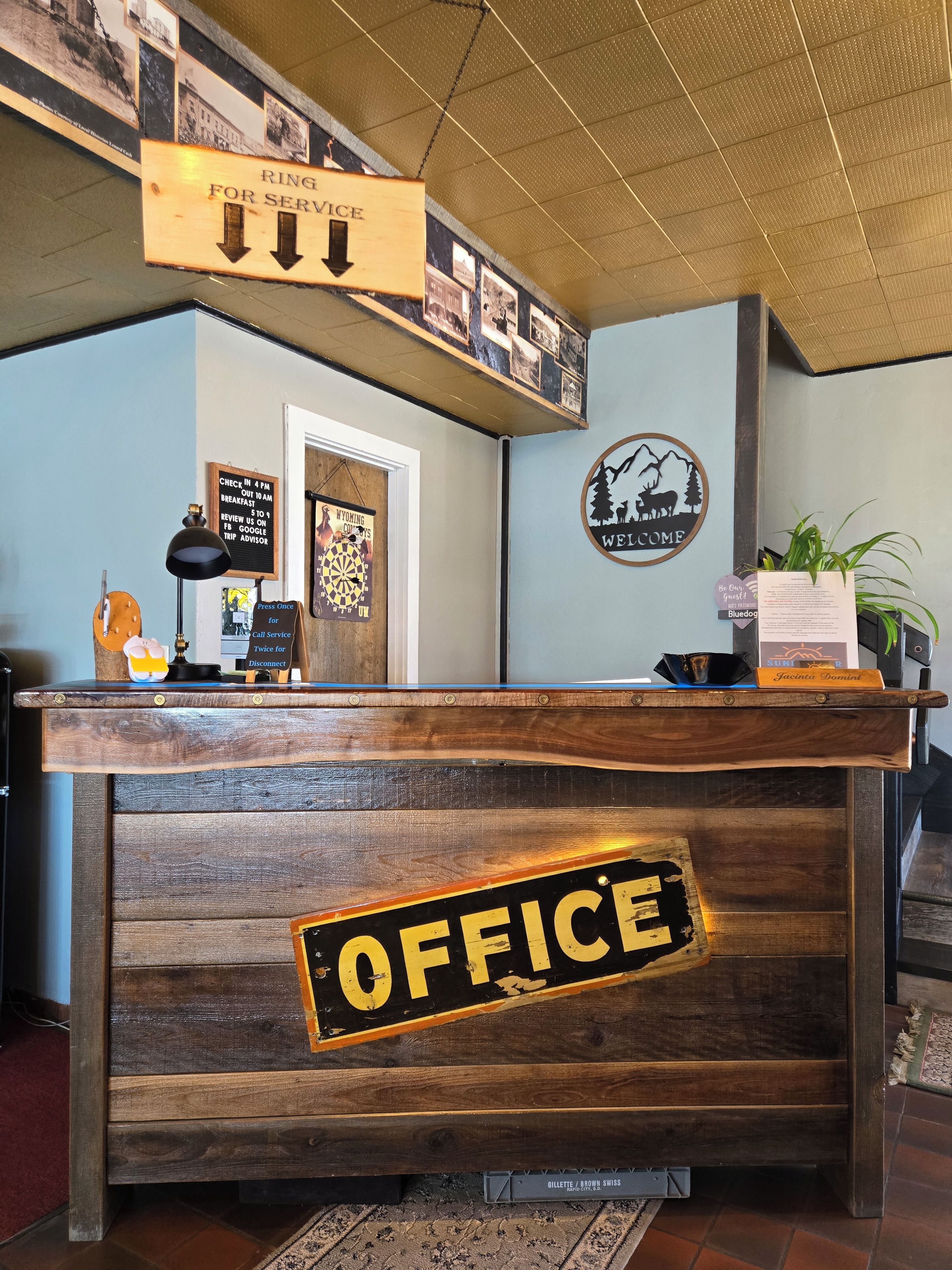 A reception desk with a wooden finish and a sign that reads 'OFFICE'.