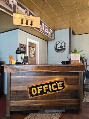 A reception desk with a wooden finish and a sign that reads 'OFFICE'.