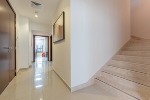 Ein aufgeräumter, moderner Flur mit einer Treppe, die zu einer oberen Etage führt.