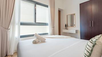 Une chambre d’hôtel avec un grand lit, une fenêtre avec des rideaux, une armoire et un miroir au mur.
