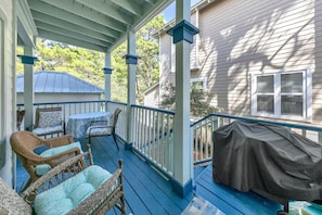 A covered porch with wicker furniture, a table, and a covered grill area. - 30A GEM Walk to The Beach 2 Pools Golf Cart + Bikes (Santa Rosa Beach)