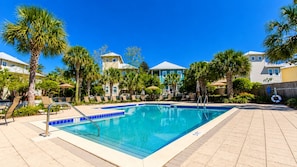 A swimming pool with lounge chairs and palm trees, surrounded by buildings. - 30A GEM Walk to The Beach 2 Pools Golf Cart + Bikes (Santa Rosa Beach)