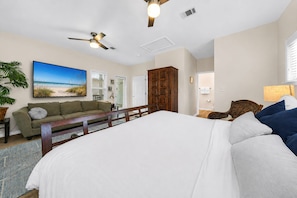 A bedroom with a large bed, a wooden headboard, a ceiling fan, and a beach-themed painting on the wall. - 30A GEM Walk to The Beach 2 Pools Golf Cart + Bikes (Santa Rosa Beach)