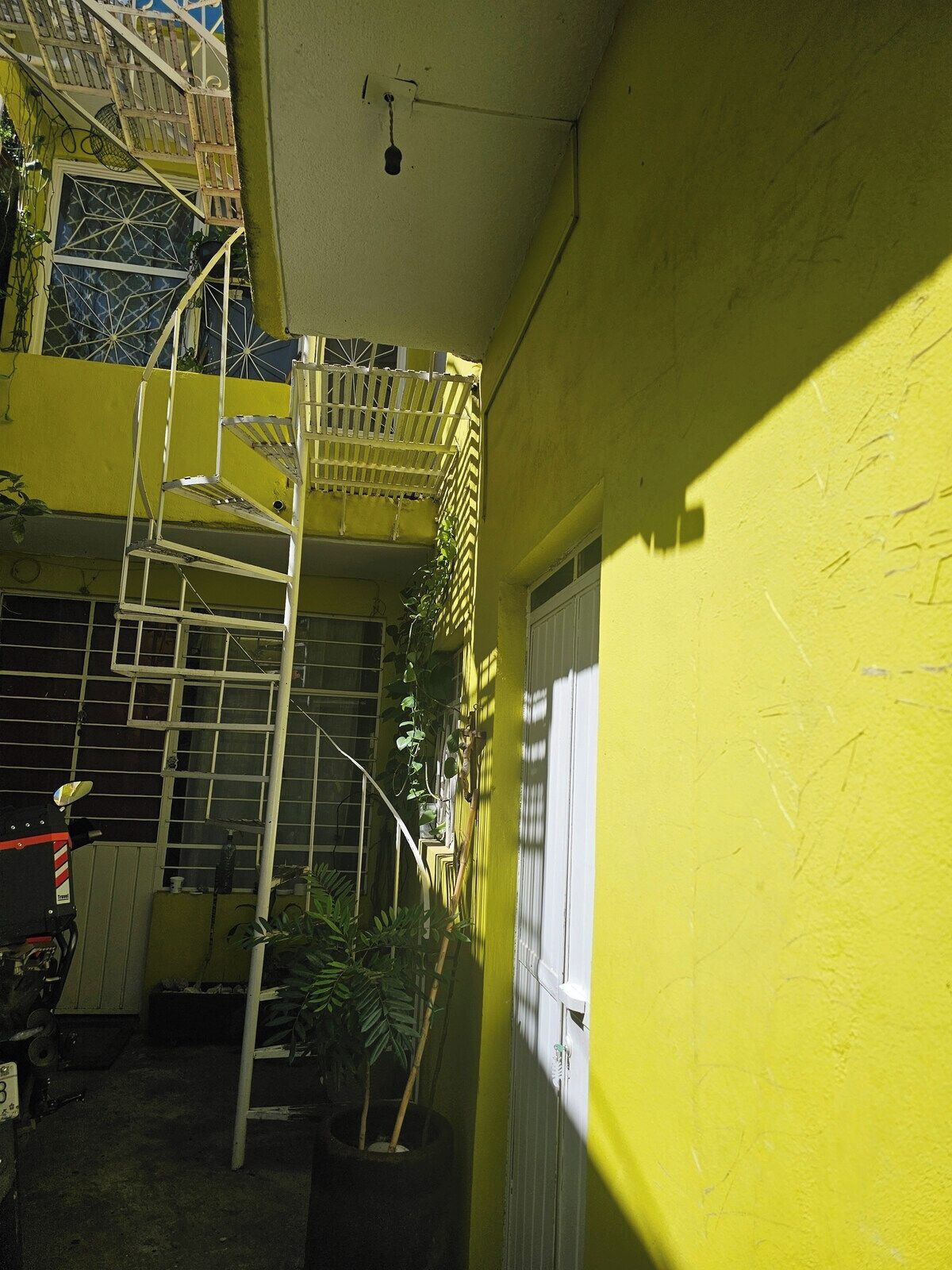 Un edificio amarillo con una escalera de metal y una ventana.