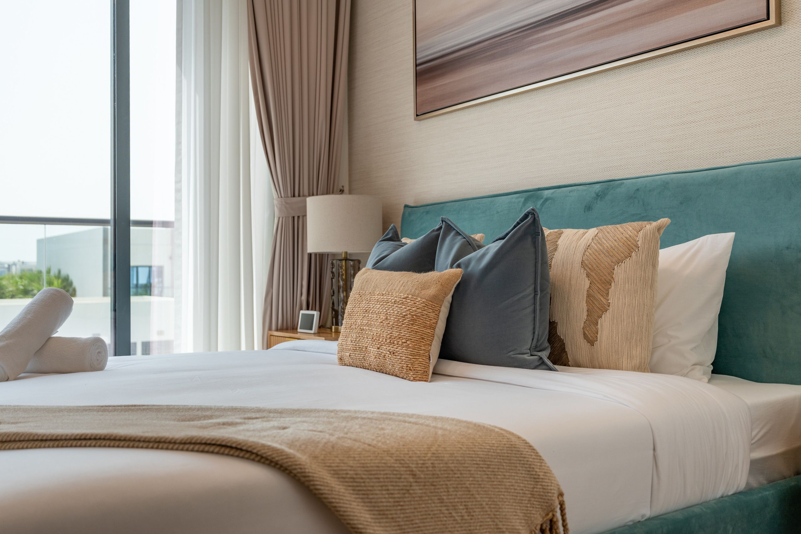 Habitación de hotel con una cama grande, vistas a la ciudad y una ventana con cortinas.