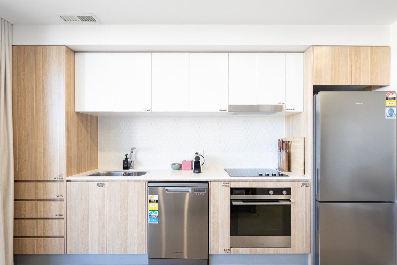 A modern kitchen with wooden cabinets, stainless steel appliances, and a built-in oven.