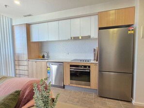 A compact kitchen with a dishwasher, oven, and refrigerator.