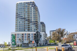 A multi-story building with a modern design, featuring balconies and large windows.
