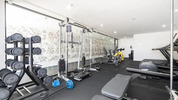 A gym with weightlifting equipment, treadmills, and exercise bikes.
