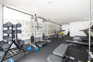 A gym with weightlifting equipment, treadmills, and exercise bikes.