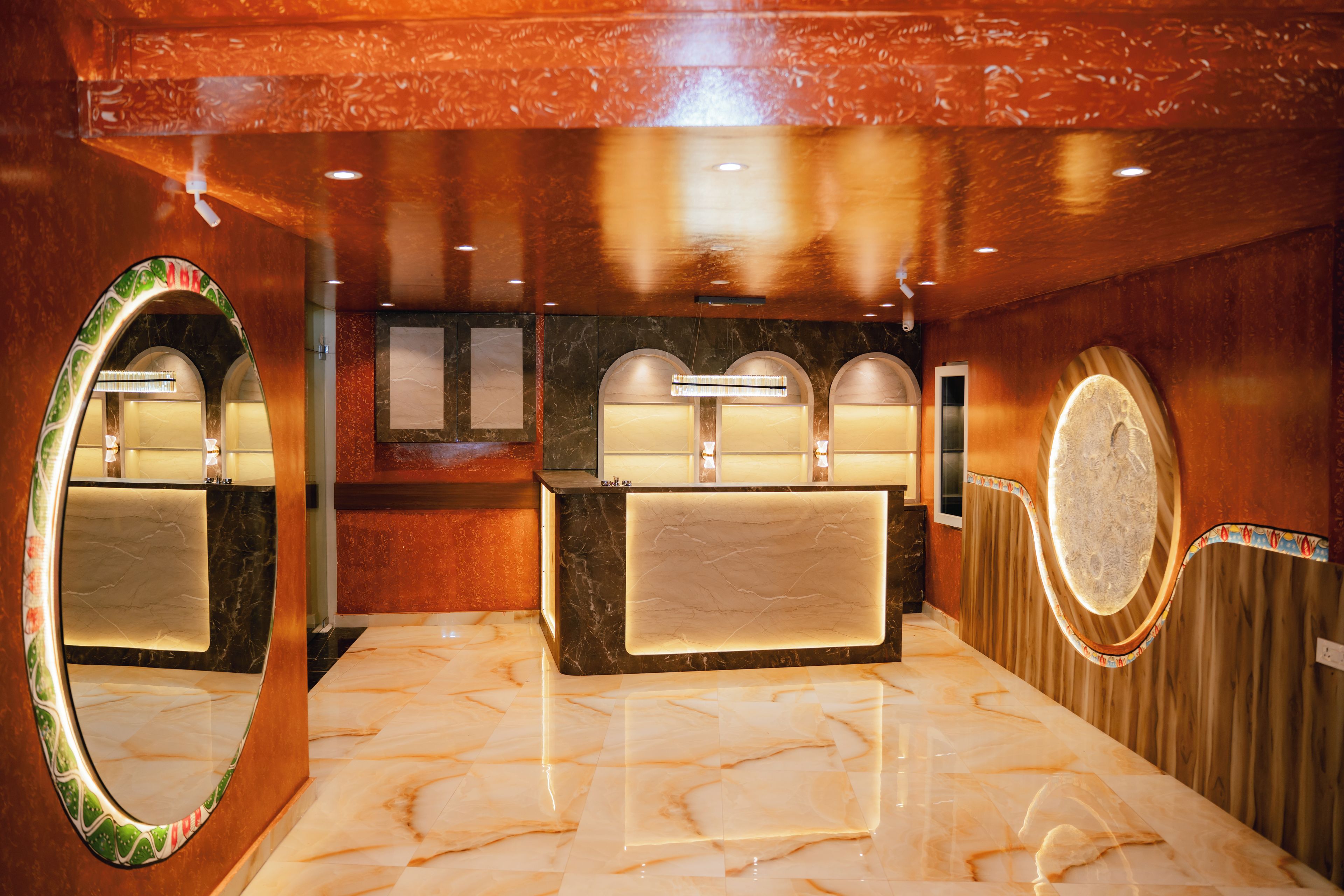 Une salle de bain avec un sol en marbre, un lavabo avec un miroir et une commode avec un éclairage.