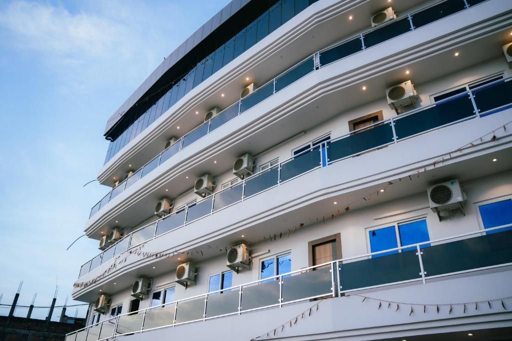 Un immeuble à plusieurs étages doté de balcons et de climatiseurs.