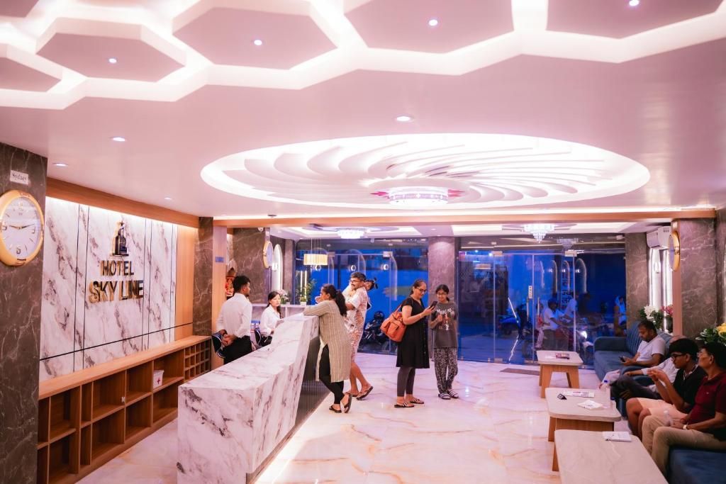 A hotel lobby with a reception desk, seating area, and a glass wall leading to the interior.