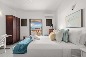 A hotel room with a bed, a desk, a wardrobe, and a view of the outside. - Vida Luna | Cozy Old San Juan Retreat + Terrace (San Juan)
