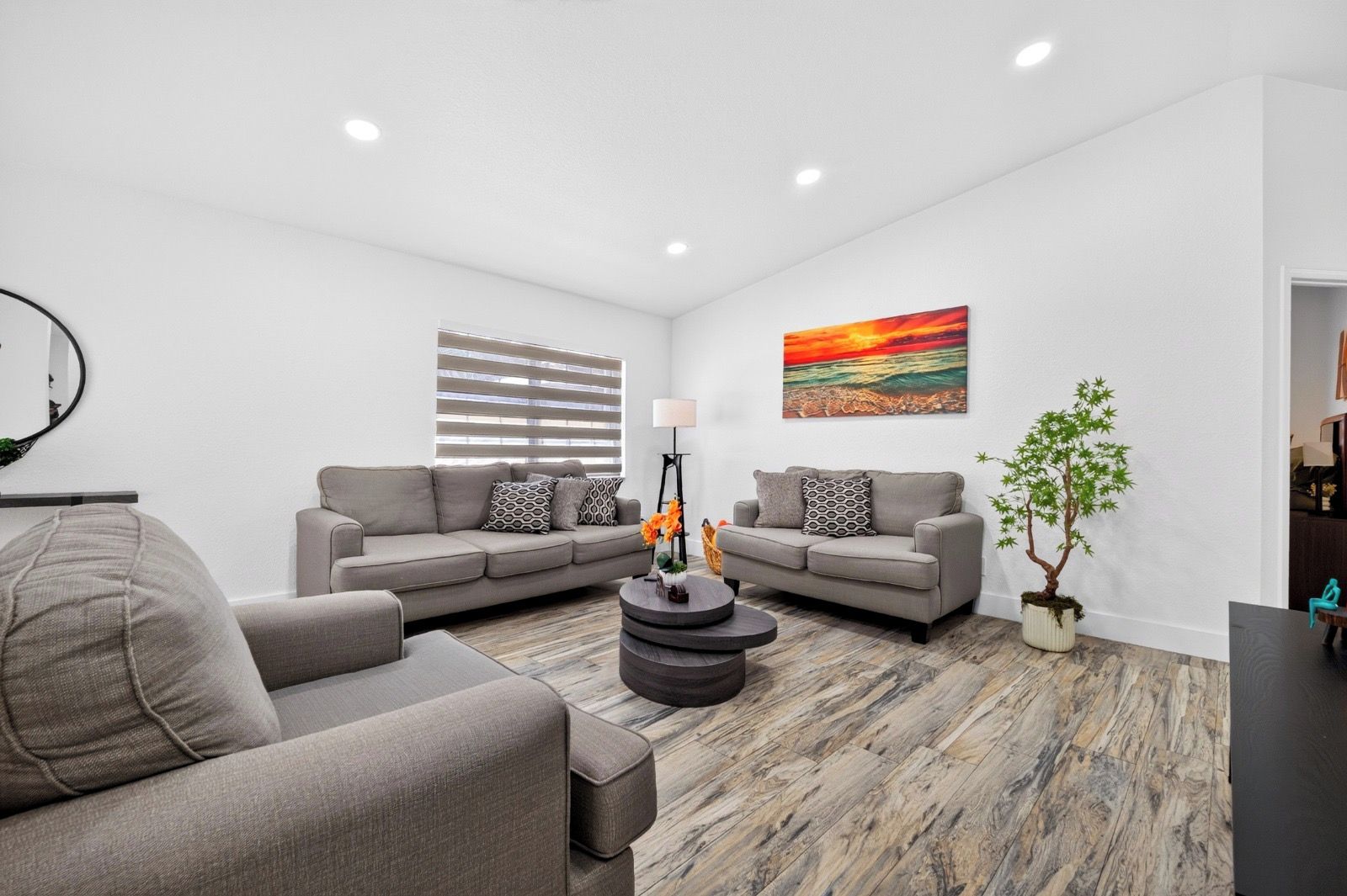 A modern living room with a sectional sofa, a round coffee table, and a potted plant.