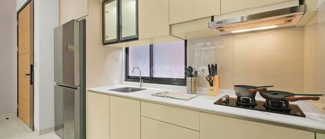 A modern kitchen with a stainless steel refrigerator, a built-in oven, a sink, and a stove.