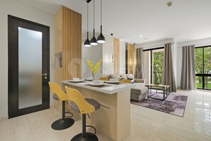 Eine moderne Küche mit Kochinsel, Barhocker und Pendelleuchten.
