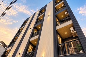 Ein mehrstöckiges Gebäude mit Balkonen, großen Fenstern und modernem architektonischem Design.