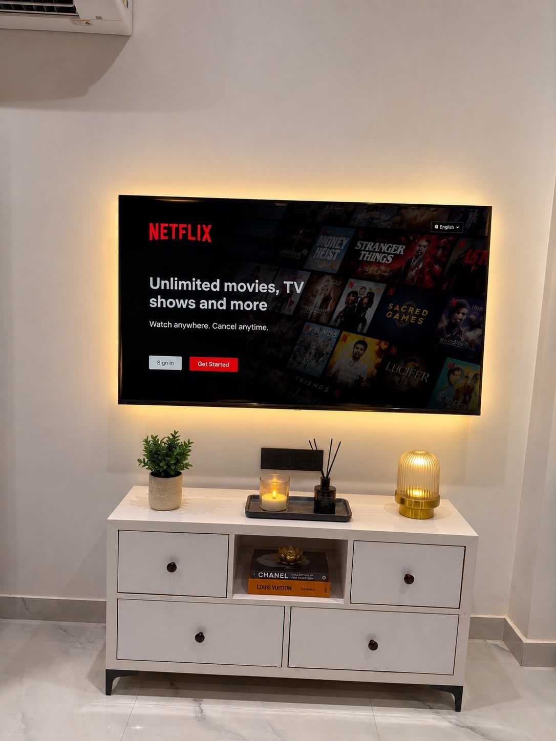 Televisor de pantalla plana montado en la pared mostrando la interfaz de Netflix con una selección de películas y series.