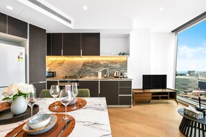 A modern kitchen with a marble countertop and a city view. - Harbour View 1BR Escape | Pool, Gym & Sauna (Melbourne)