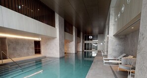 An indoor swimming pool with a clear view of the pool area, seating arrangements, and a modern architectural design. - Harbour View 1BR Escape | Pool, Gym & Sauna (Melbourne)