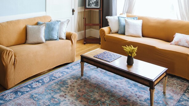 A living room with two sofas, a coffee table, a chandelier, a framed picture, and a window with curtains. - Large Apartment Between Bates, St. Mary’s & CMMC (Lewiston)