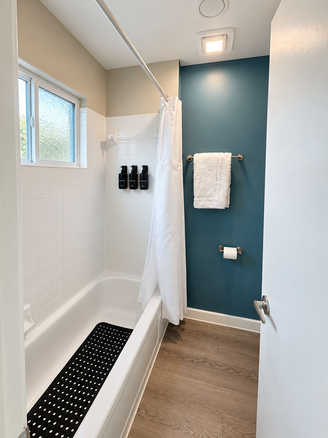 Une salle de bain moderne avec une baignoire, un rideau de douche et un porte-serviettes.