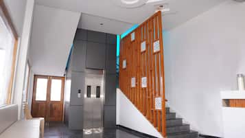 Een modern interieur met een trap, een keuken en een deur naar een andere kamer.