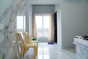 A room with a marble floor, a window with curtains, and a bed with a patterned bedspread. - SRT Convention & Hotel (Tadpatri)