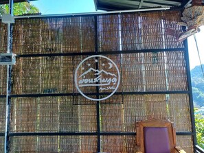 A bamboo fence with a circular logo featuring a mountain and text.