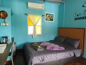 Un dormitorio con cama, escritorio y ventana con cortinas.