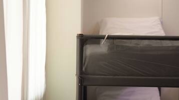 A bunk bed with a headboard, a white pillow, and a blanket.