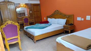 Un dormitorio con una cama doble, una silla, un escritorio y un armario.