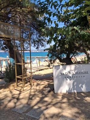 A beachside sign for La Plage Blanche Portico with a view of the sea and beach in the background. - A LUMERIA Maison paisible 2 chambres avec clim et piscine partagée à Porticcio (Grosseto-Prugna)