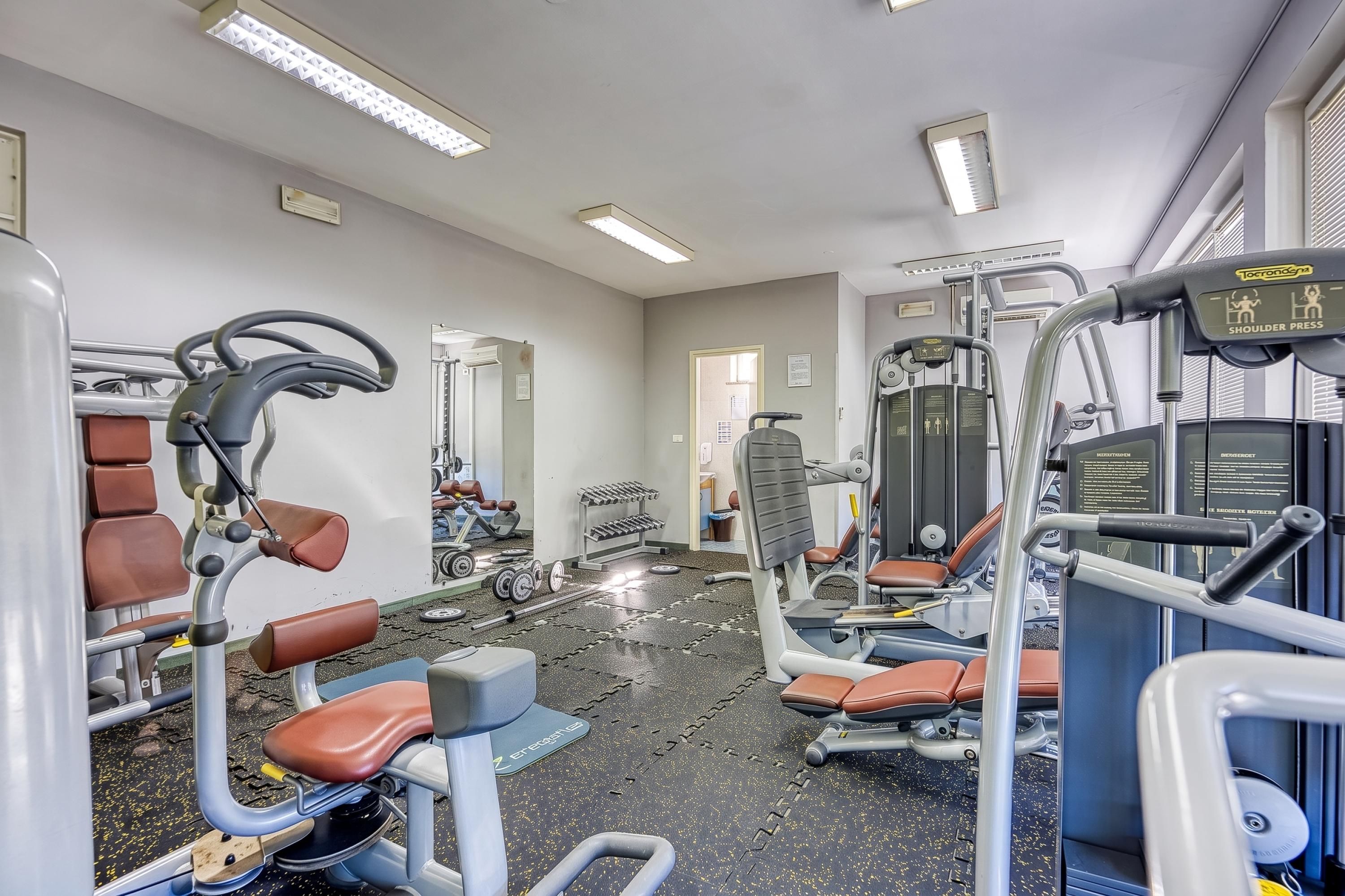 A gym with various exercise equipment, including weight machines and free weights.
