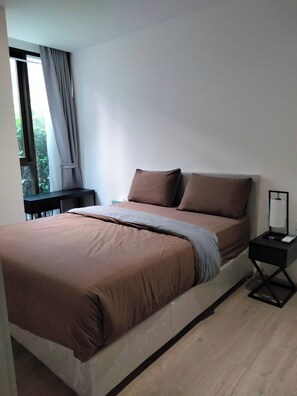A modern bedroom with a large bed, a nightstand, and a window with curtains. - 6 Star Luxury at The Heart of Bangkok (Bangkok)