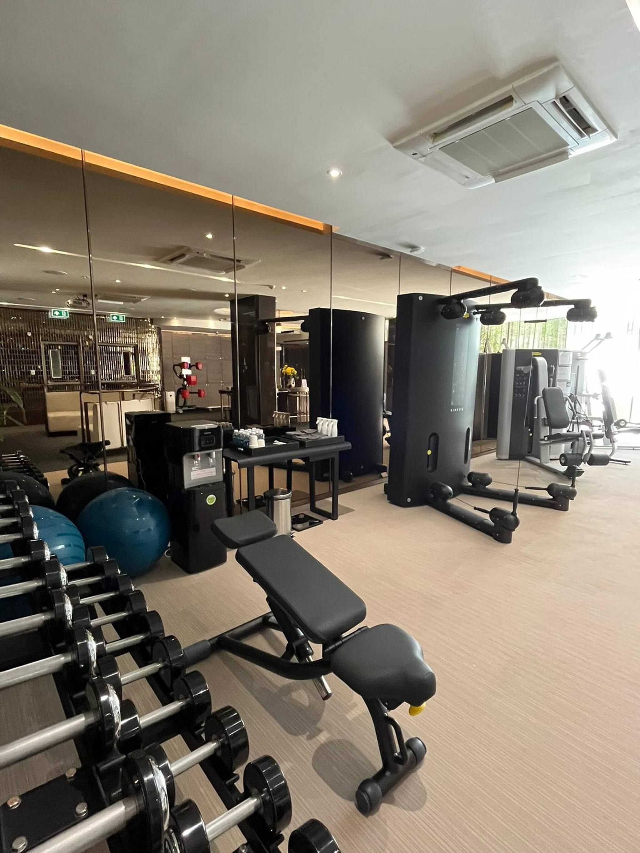 A gym with exercise equipment, benches, and a weight rack.