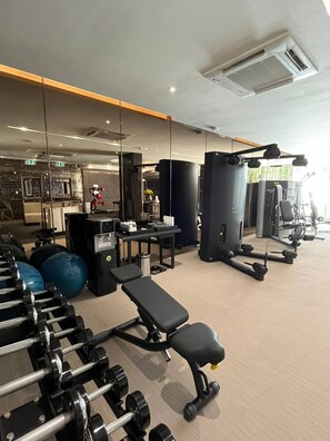 A gym with exercise equipment, benches, and a weight rack. - 6 Star Luxury at The Heart of Bangkok (Bangkok)
