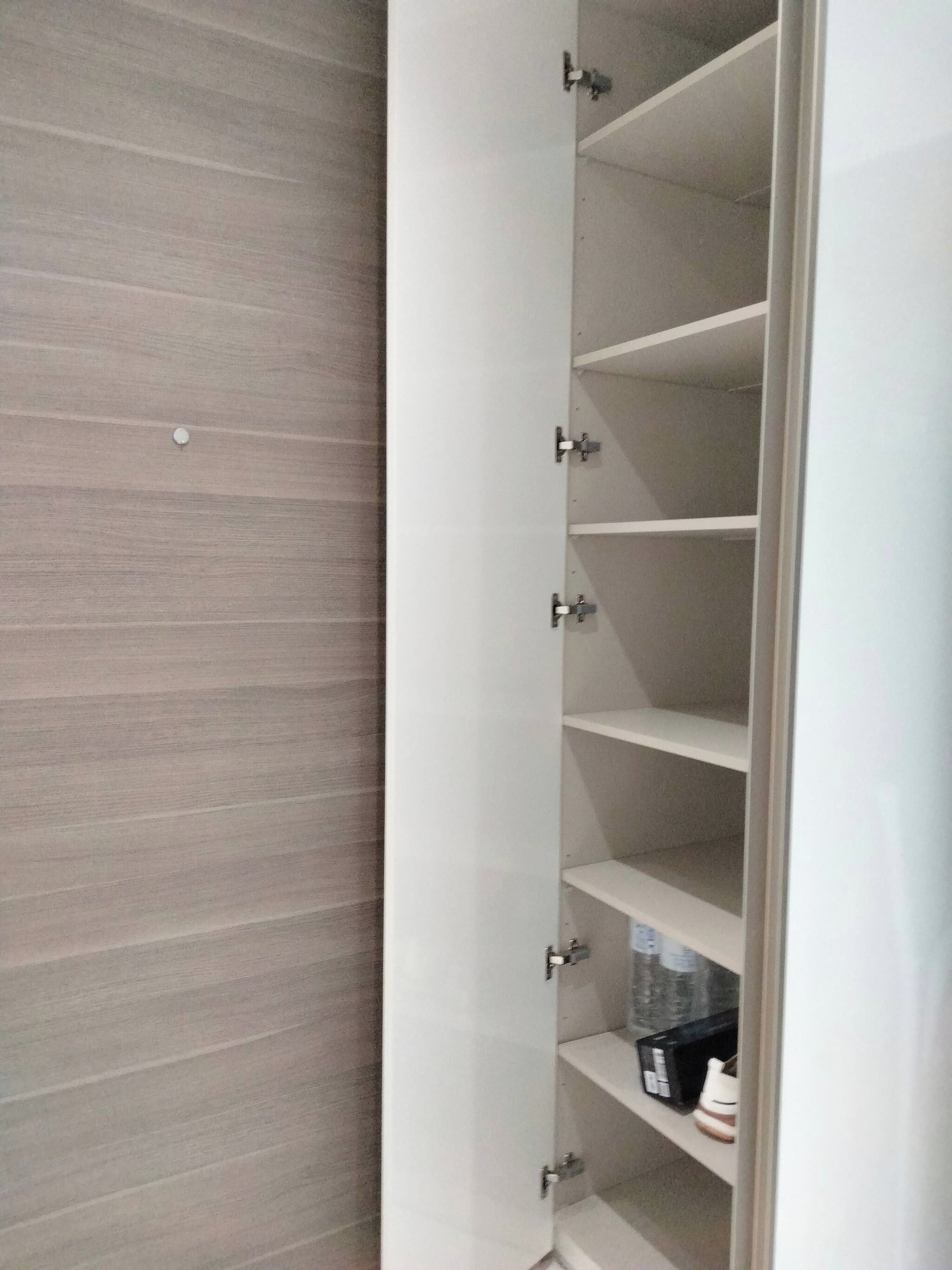 A white shelving unit with multiple compartments, some containing items.