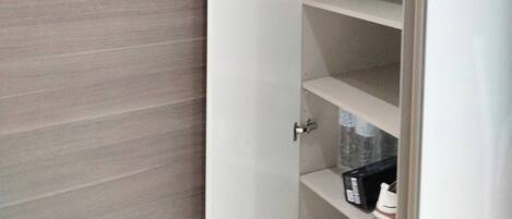 A white shelving unit with multiple compartments, some containing items.