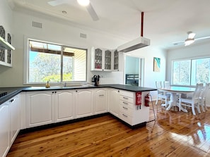 A kitchen with white cabinets, a black countertop, and wooden flooring.