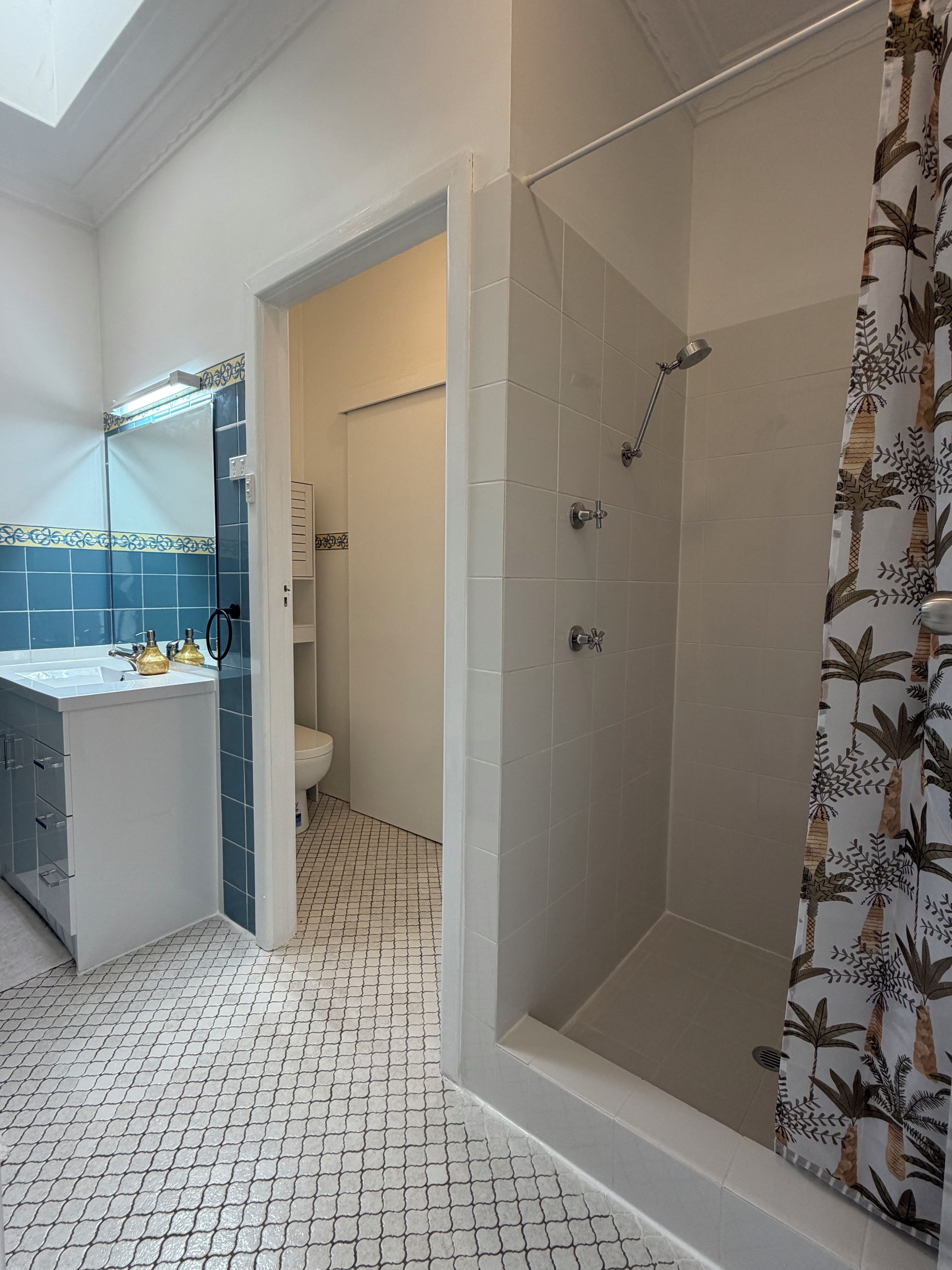 A bathroom with a shower, toilet, and sink.