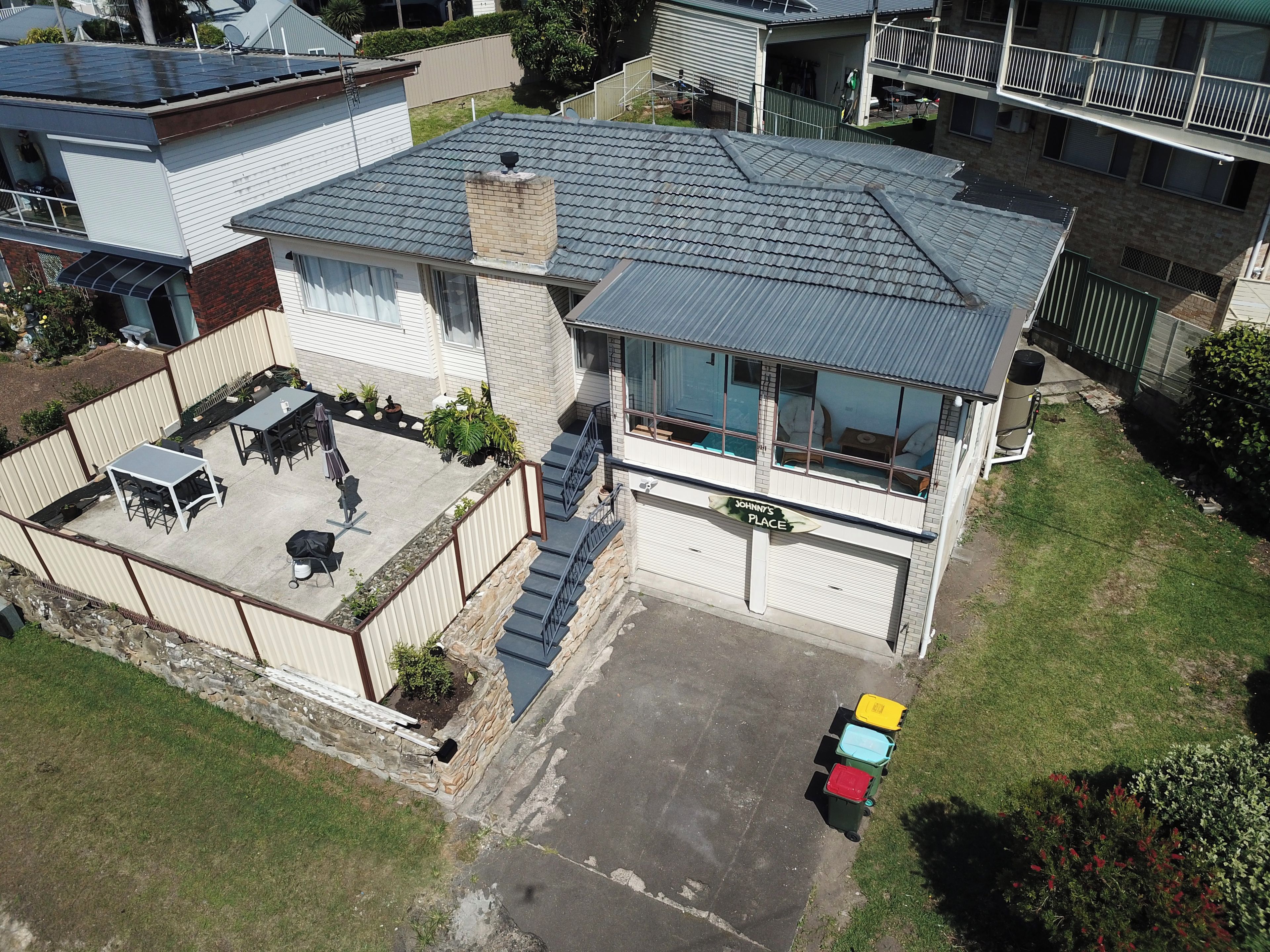 A two-story house with a covered patio, a garage, and a fenced backyard.