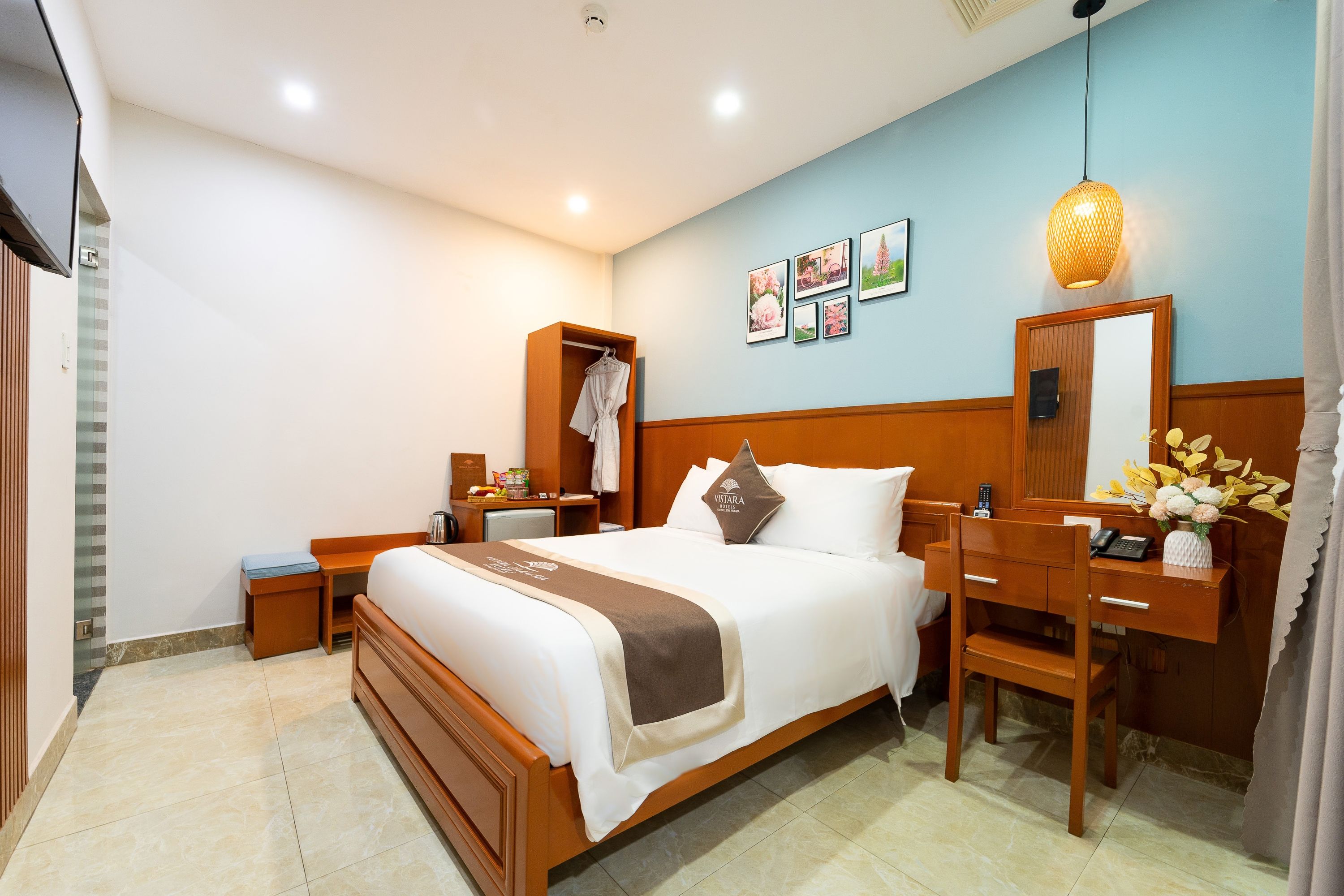 Una habitación de hotel con cama, mesita de noche, escritorio, silla y armario.