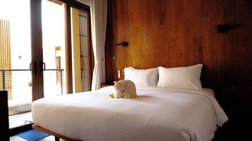Una habitación de hotel con una cama grande, paredes de madera y vistas a través de un ventanal corredero.