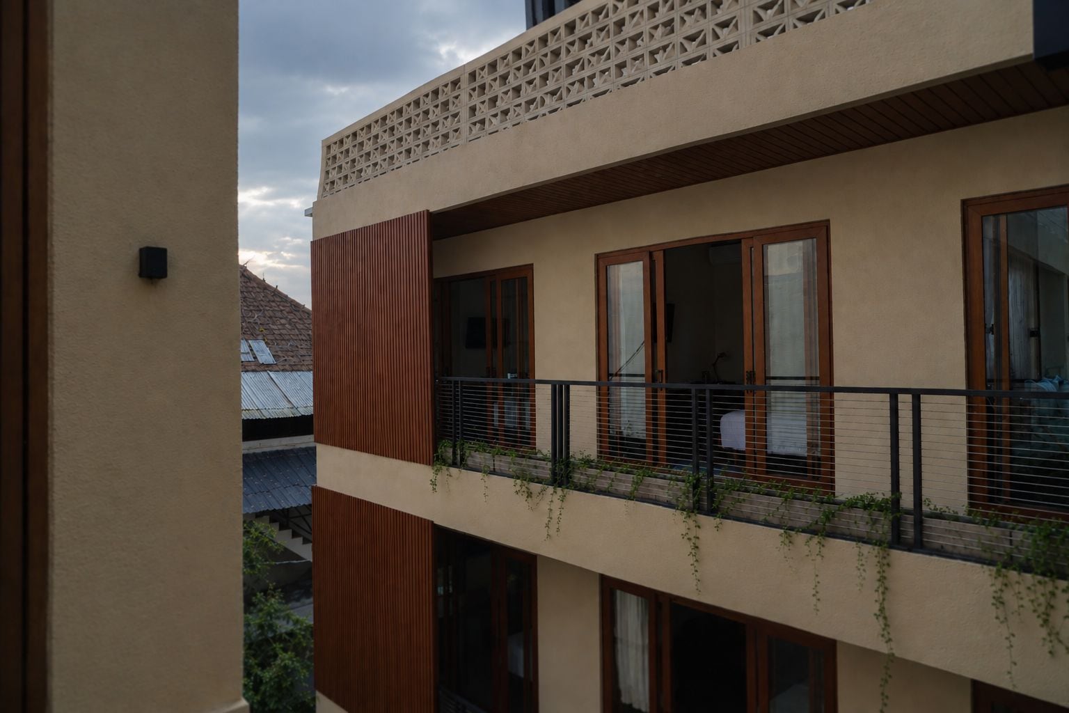 A multi-story building with balconies, large windows, and a visible rooftop.